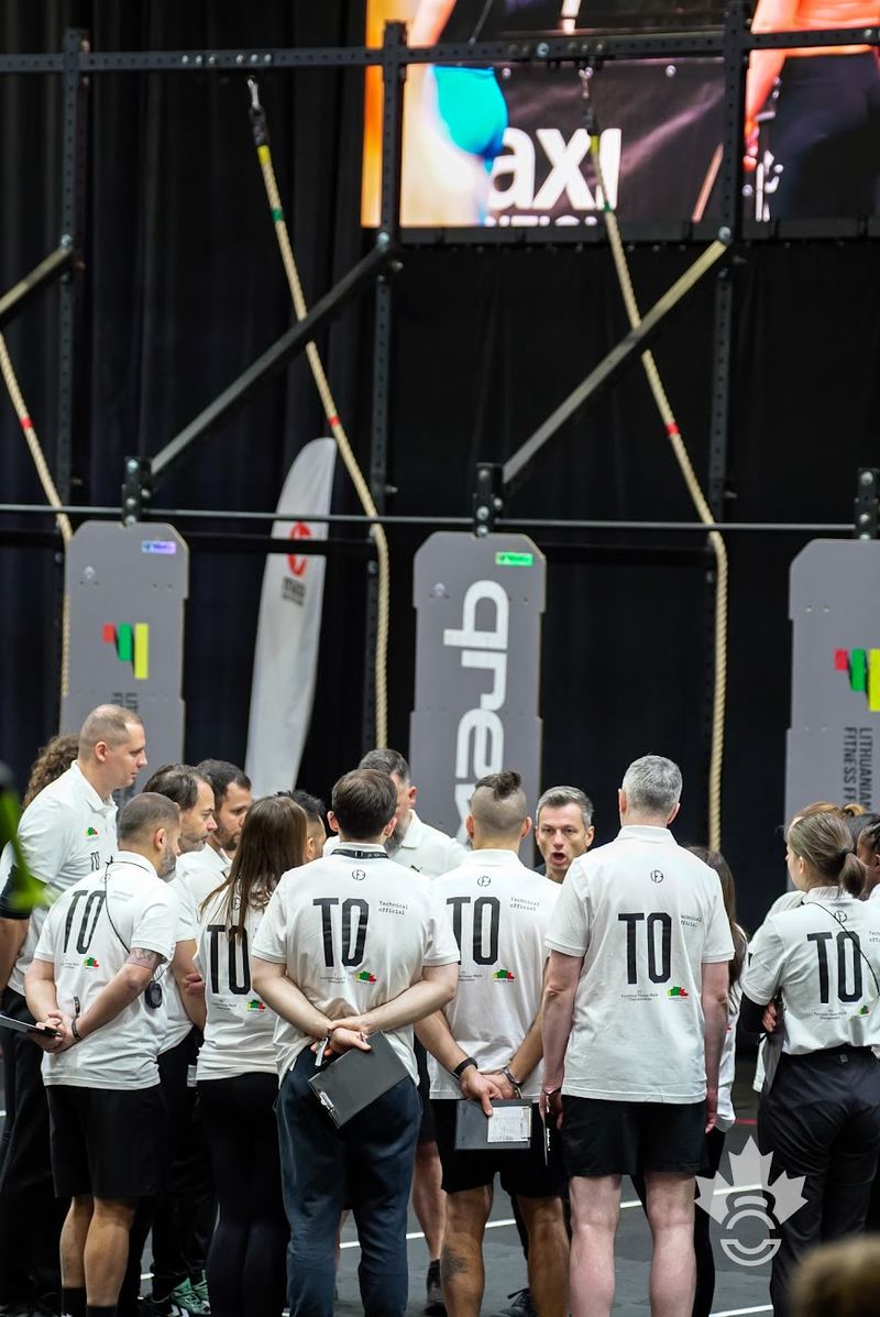 Technical Officials gathered in a huddle for a briefing in front of the rig